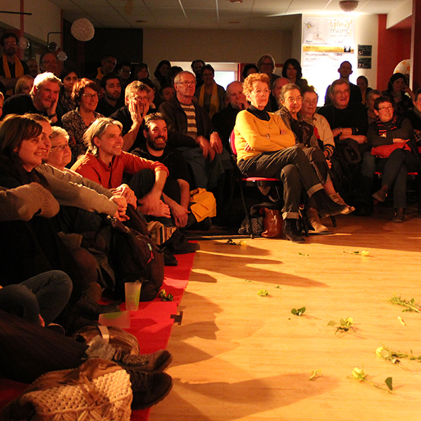 Des spectateurs sourient en regardant un spectacle.