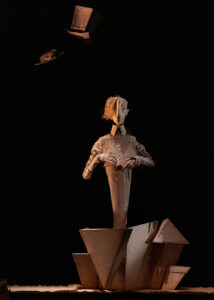 Une marionnette de chapelier est sur scène.