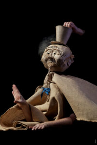 Une marionnette avec un chapeau est sur scène.