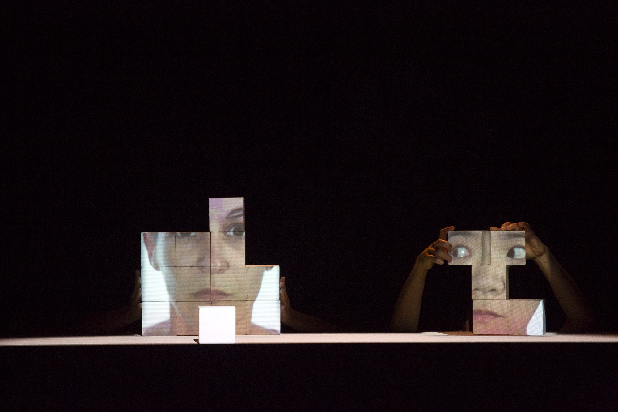 CUBIX Des visages sont projetés sur des cubes blancs.