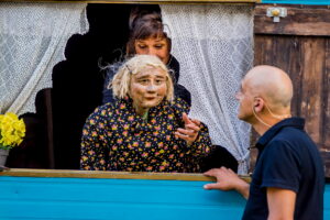 La marionnette est à la fenêtre et parle avec le comédien.