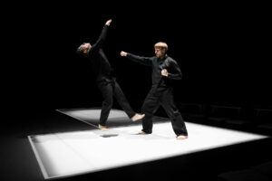 Un danseur fait semblant de frapper avec son poing l'autre danseur qui part en arrière.