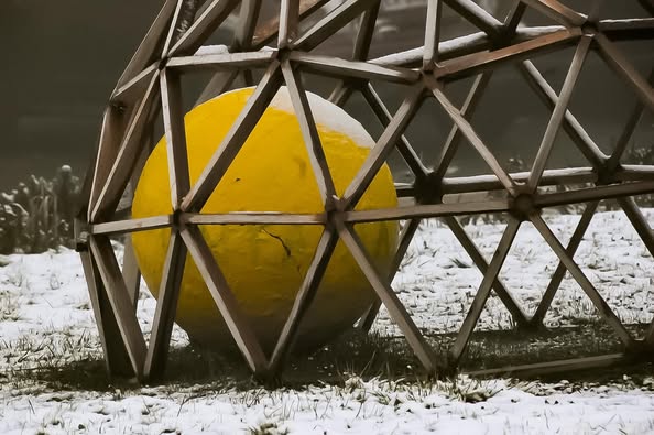 La boule jaune de Tinta'mars, sur un rond-point de Langres, est sous la neige.