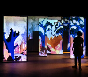 Personnage de dos devant des panneaux représentant un paysage japonais.