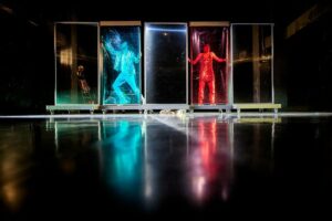 Les danseurs sont dans des boîtes transparentes, une rouge et l'autre bleue.