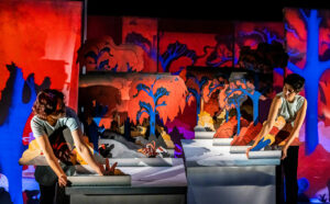 Les deux comédiens manipulent plusieurs personnages de papier.