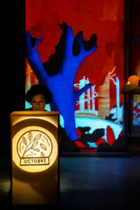 La comédienne est entre plusieurs panneaux avec des ombres projetées.