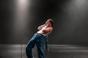 Une danseuse se tient le visage entre les mains et a le vissage tendu.