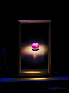 Photo d'un cadre avec une image de pomme rouge entourée de lumière.