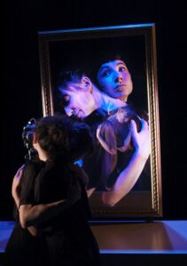 Les deux comédiennes se prennent dans les bras, il y a un reflet dans un faux miroir.
