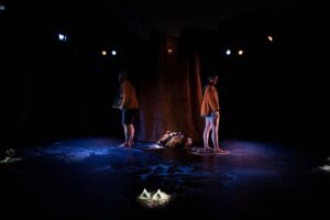 Les deux comédiens sont dos à dos sur la scène.