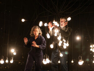 Les deux comédiens nouent des ampoules suspendues entre elles.