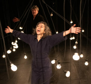 La comédienne sourit, les bras grands ouverts et le visage vers le ciel.