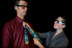 La comédienne ajuste la cravate du comédien.