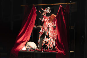 Le comédien est recouvert de rubalise rouge et blanche.