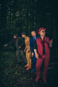 Les quatre musiciens marchent dans une foret.