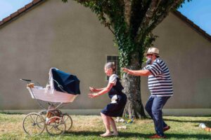 Les deux grands-parents se rapprochent de la poussette.