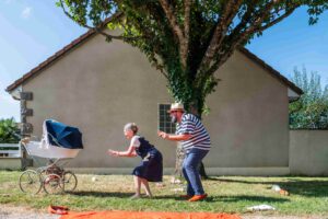 Les deux grands-parents courent vers la poussette.