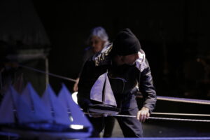 Le comédien fait avance un bateau sur un fil.