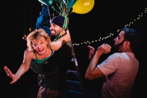 Les trois danseurs dansent, accrochés à des ballons.