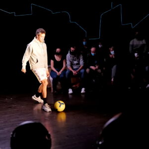 Le comédien joue avec un ballon de foot.