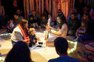 La comédienne tend un miroir vers un enfant.