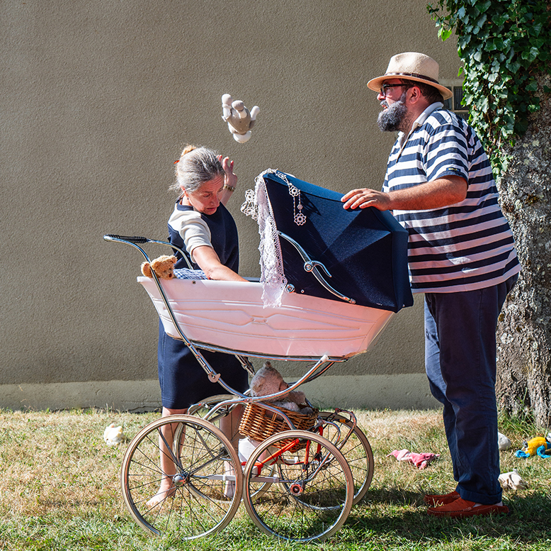 Les grands-parents sont autour du landau de leur petit-enfant.