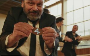 Le chanteur montre un jeton avec le numéro 4 inscrit dessus.
